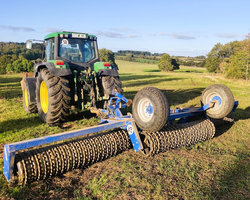 Ein Traktor walzt die Weidefläche bei Birx auf der vorher das Saatgut für eine Blühwiese ausgebracht wurde.
